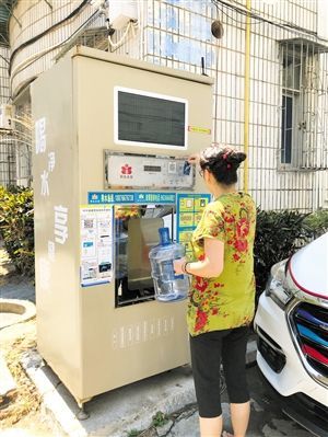 5月24日，瓊山區(qū)上丹花苑小區(qū)居民陳女士在使用共享凈水機(jī)取水。 本報記者 陳歆卓 攝